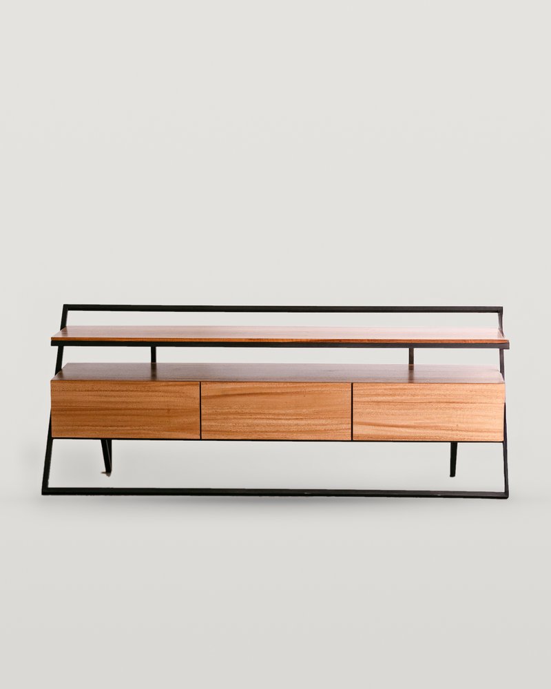 Centro de TV Monaco: estructura trapezoidal de acero negro, repisa superior de madera y gabinete de madera miel con tres cajones sin jaladeras, sobre fondo hueso